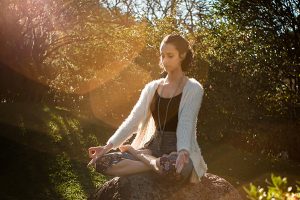 Meditation and Kratom image of a woman in a meditation pose in the woods